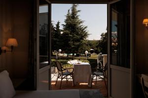 Hotel PAX Torrelodones في توريلودونيس: غرفة مع شرفة مع طاولة وكراسي