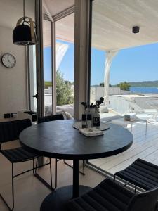 a table and chairs in a living room with a view at BUQEZ ECO RESORT - Beach Villas 2 and 8 - Seaview, new wifi! in Drage