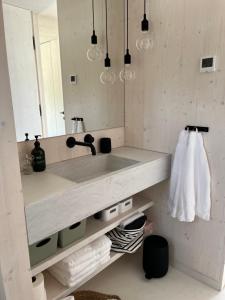 a bathroom with a sink and a mirror at BUQEZ ECO RESORT - Beach Villas 2 and 8 - Seaview, new wifi! in Drage