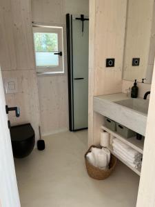 a bathroom with a sink and a toilet and a window at BUQEZ ECO RESORT - Beach Villas 2 and 8 - Seaview, new wifi! in Drage