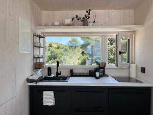 a kitchen with a sink and a window at BUQEZ ECO RESORT - Beach Villas 2 and 8 - Seaview, new wifi! in Drage