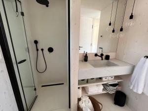 a bathroom with a sink and a shower at BUQEZ ECO RESORT - Beach Villas 2 and 8 - Seaview, new wifi! in Drage