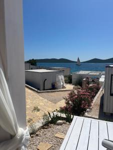 a view of the water from a house with a bench at BUQEZ ECO RESORT - Beach Villas 2 and 8 - Seaview, new wifi! in Drage +37 photos