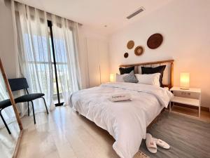 1 dormitorio con 1 cama grande y un par de zapatillas en Malaga House, en La Marsa 11 fotos más