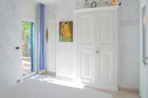 Dieses weiße Zimmer verfügt über eine Tür und ein Fenster. in der Unterkunft 071 - CASA GIOIELLO, GIARDINO, 10 minuti MARE SPIAGGIE in Sestri Levante
