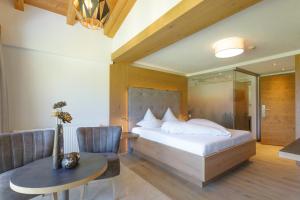 a bedroom with a bed and a table and a chair at hin&weg das Aparthotel in Ried im Zillertal