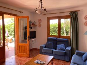 a living room with two blue chairs and a table at Beautiful Villa & Swimming Pool in Cala Blanca in Cala Blanca