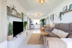 ein Wohnzimmer mit Sofa und Fernseher in der Unterkunft Acogedor Apartamento con vistas al mar en Costa Adeje in Adeje