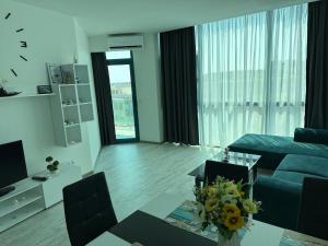 a living room with a couch and a table with flowers at Spacious and cozy Apartment in complex Del Sol in Primorsko