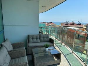 a balcony with couches and a table on a building at Spacious and cozy Apartment in complex Del Sol in Primorsko