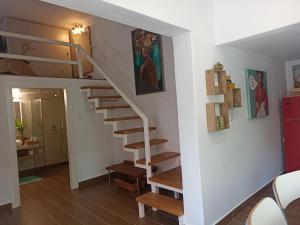 - un escalier dans une maison dotée de murs blancs et de parquet dans l'établissement Cosy loft, à Platamonas