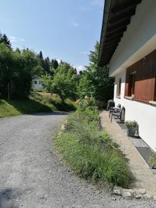 uma estrada de cascalho com um banco ao lado de um edifício em Ferienwohnung in Schwarzach Vorarlberg em Schwarzach
