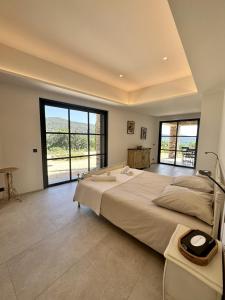 a large bedroom with a large bed and large windows at Le Mas Saint Michel Grimaud in Grimaud