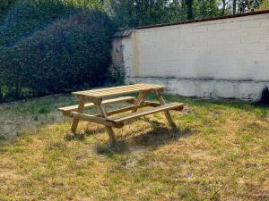 una mesa de picnic de madera en el césped en Appart'Hôtel Le Jaurès - Jardin privé et Netflix, en Belfort