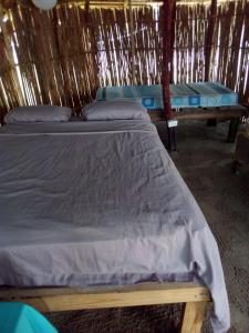 a bedroom with two beds in a straw hut at Gunayar amazing in Arritupo Número Dos