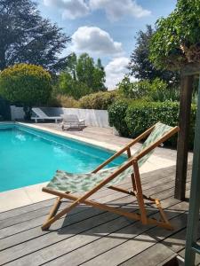 una sedia seduta su una terrazza accanto alla piscina di Maisonnette tout confort a Rochefort-du-Gard