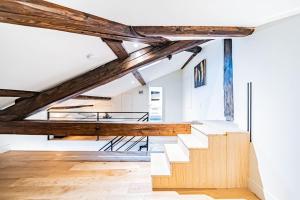 an attic room with wooden beams and stairs at Appartement Bellecour - Emplacement prime in Lyon