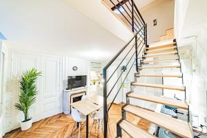 una scala in un soggiorno con tavolo e sedie di Appartement Bellecour - Emplacement prime a Lione
