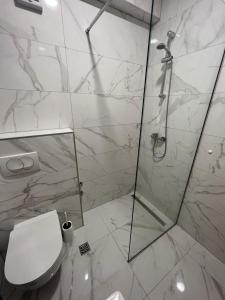 a white bathroom with a shower and a toilet at Apartments MAMPAS in Neum