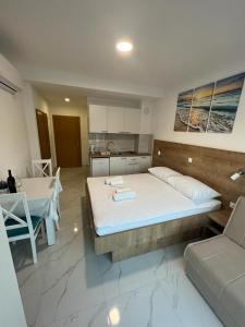 a bedroom with a large bed and a kitchen at Apartments MAMPAS in Neum