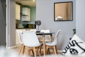 ein Esszimmer mit einem Tisch und weißen Stühlen in der Unterkunft Host & Stay - Halifax House Apt II in Liverpool