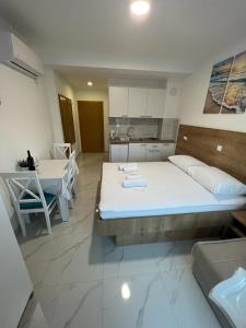 a bedroom with a large bed and a kitchen at Apartments MAMPAS in Neum