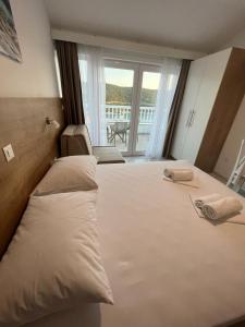 1 Schlafzimmer mit 2 Betten und Blick auf einen Balkon in der Unterkunft Apartments MAMPAS in Neum