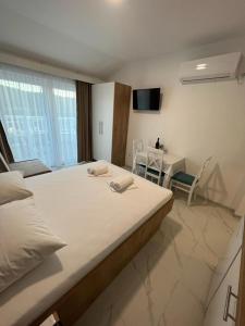 1 Schlafzimmer mit einem großen Bett und einem Esszimmer in der Unterkunft Apartments MAMPAS in Neum