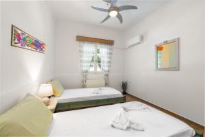 a bedroom with two beds and a ceiling fan at St. Harry's Windmill in Makris Gialos