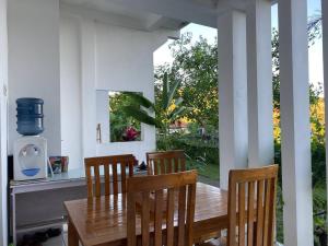 a dining room with a wooden table and chairs at The Hill View Lombok in Kuta Lombok