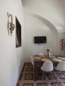 ein Esszimmer mit einem Holztisch und Stühlen in der Unterkunft Appartamento Porta Lecce in Brindisi