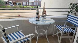 比尼亞德爾馬的住宿－迪帕特門托阿誇瑪爾公寓，一张小桌子,上面有帆船,旁边是两把椅子