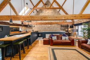 an open kitchen and living room with exposed beams at Luxury town centre loft apartment in converted Granary in Stamford