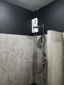 um chuveiro numa casa de banho com uma parede preta em Nimman 9 em Chiang Mai
