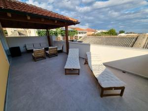 a patio with two benches and a table and chairs at Villa Paro in Pag