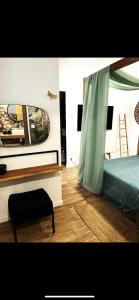 een slaapkamer met een bed, een spiegel en een stoel bij Résidence la palmeraie Piscine & SPA pour 4 personnes NEW YORK in Lapalme