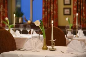 Una mesa con vasos y una flor blanca en un jarrón. en Cella Central Historic Boutique Hotel, en Zell am See