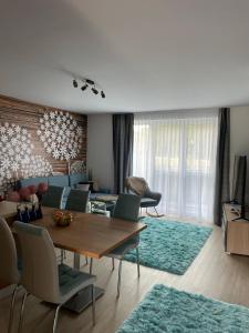 sala de estar con mesa, sillas y sofá en Jázmin Apartman en Sárvár