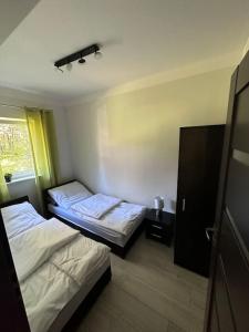 Un pat sau paturi într-o cameră la Domek nad jeziorem - Białka