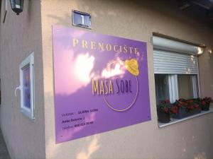 a purple sign on the side of a building at sobe MAŠA in Subotica