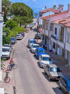 a person riding a bike down a street with parked cars at Abelia Otel in Çanakkale