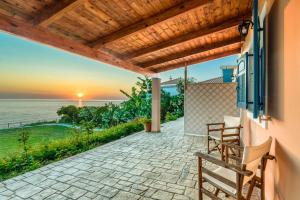 a patio with a view of the ocean at St. Harry's Windmill in Makris Gialos