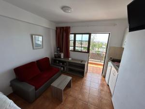 a living room with a red couch and a table at Parquemar in Playa del Ingles