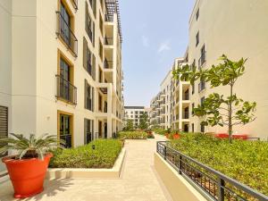 een flatgang met gebouwen en planten bij HiGuests - Stylish Waterfront Retreat With Balcony in La Mer in Dubai