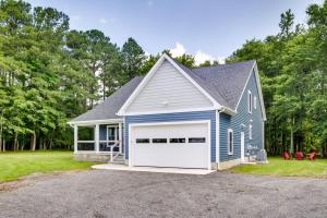 a blue house with a white garage at Christys Cottage with Hot Tub - 2 Mi to Beach! in Snow Hill