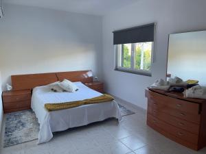 ein Schlafzimmer mit einem Bett, einer Kommode und einem Fenster in der Unterkunft Estrela do Geres in Geres