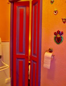 a red door in a bathroom next to a toilet at Les p'tits vélos in Chandolas
