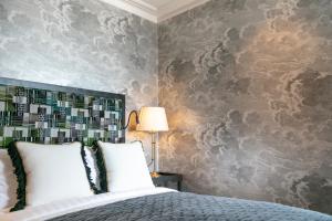 a bedroom with a bed and a wall with wallpaper at The City of London Club in London