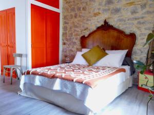 a bedroom with a bed with a stone wall at Les p'tits vélos in Chandolas