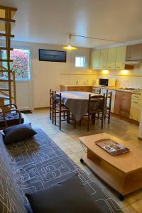 a living room with a table and a kitchen at Carnac - Maison - Environnement nature et spacieux - 4-5 km des plages in Carnac +14 photos